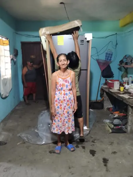 Socia junto a un refrigerador adquirido para su hogar